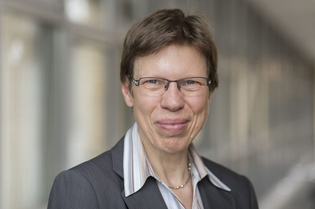 Porträtfoto von Dr. Irina Sens, die kurze braune Haare hat und eine Brille trägt.